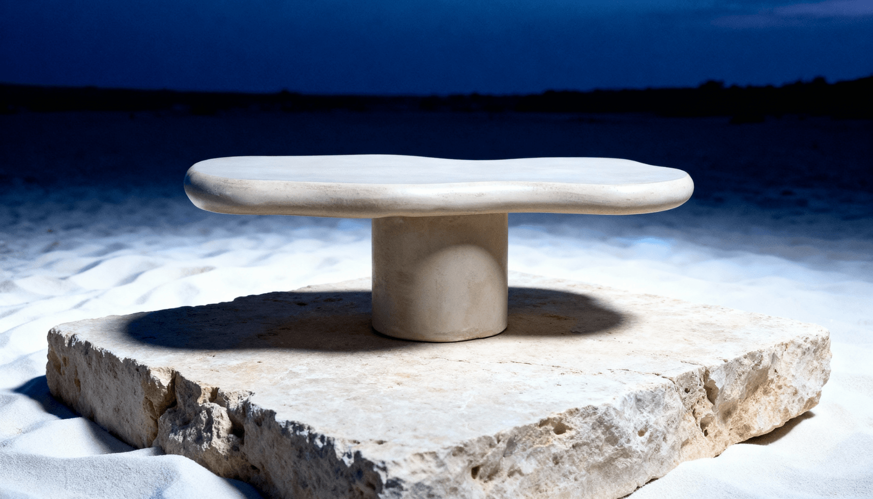 Moderne stenen tafel op een vierkante plaat rust op wit zand onder een schemerige hemel.