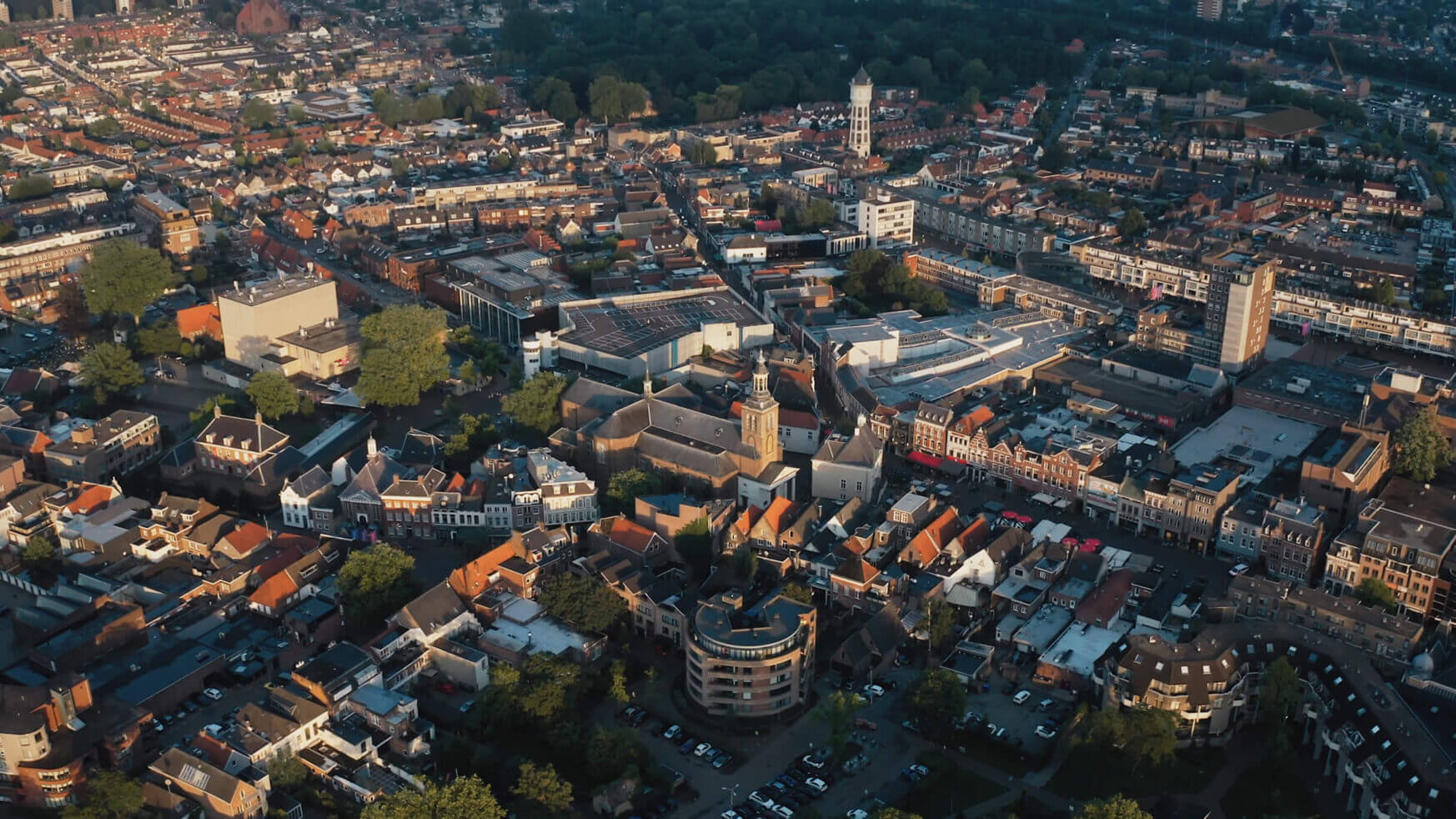 Luchtfoto van Roosendaal: dichtbebouwde woningen, wegen en groene ruimtes tonen de charme die Citymarketing uitstraalt.