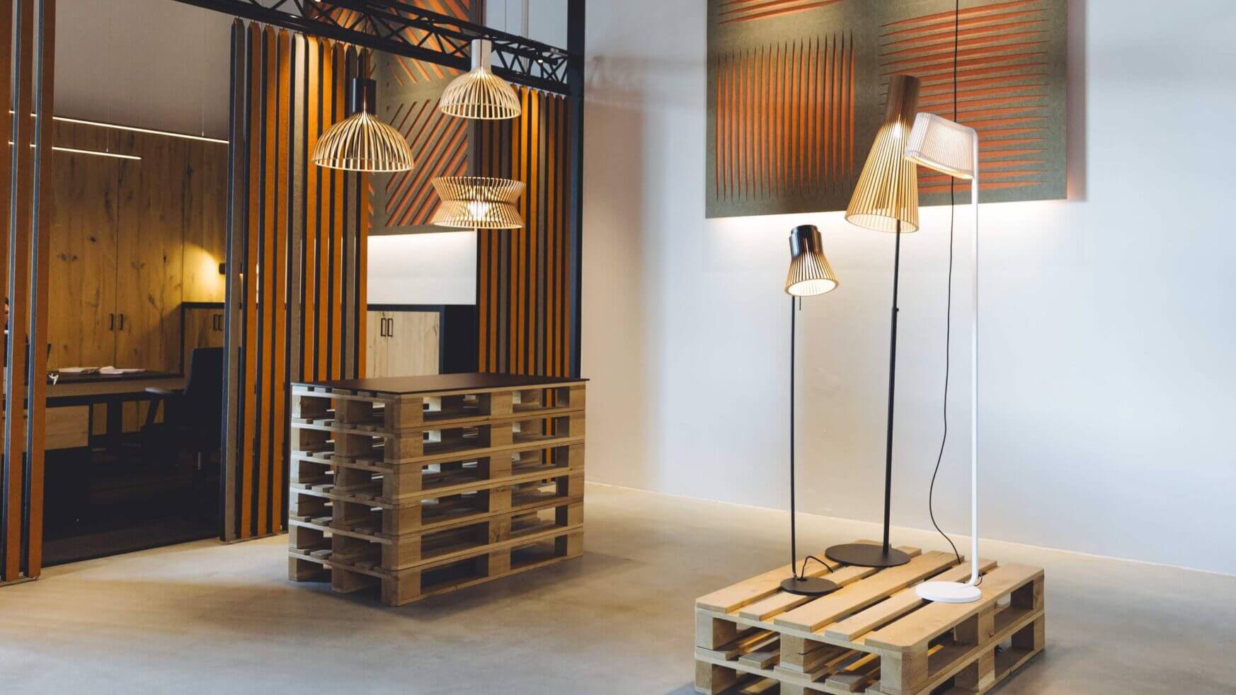 Ontdek de showroom van TunnelmaDesign met palletmeubilair, stijlvolle verlichting en akoestische panelen voor perfecte harmonie.