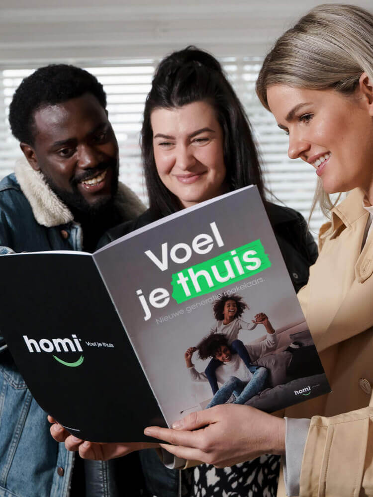 Drie lachende mensen lezen een brochure 'Voel je thuis' met daarin een familiefoto.