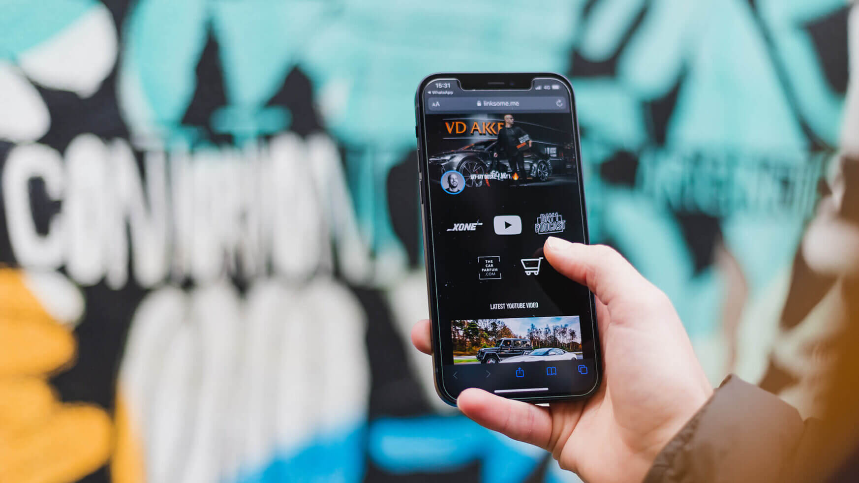 Smartphone met geopende webpagina, tegen een levendige, wazige graffiti-achtergrond.