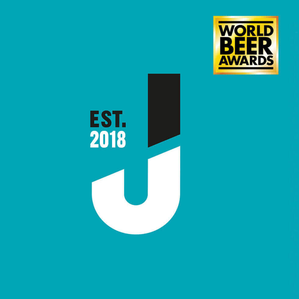 Turquoise design met een stijlvolle J, "Est. 2018" markeert de elegantie van Jubel Beer. Het logo van de World Beer Awards benadrukt de lofbetuiging.