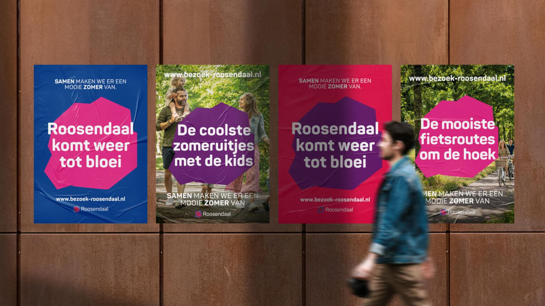 Een persoon loopt langs een muur die versierd is met vier opvallende posters van evenementen in Roosendaal.
