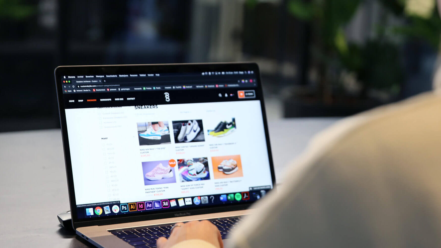Een gebruiker bladert op zijn laptop door een schoenensite en ziet trendy sneakercampagnes die gericht zijn op liefhebbers.