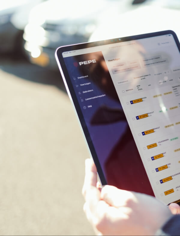 Persoon houdt een tablet vast waarop het PEPE-dashboard met Koppert Cress-merk te zien is; auto's vervagen op de achtergrond.