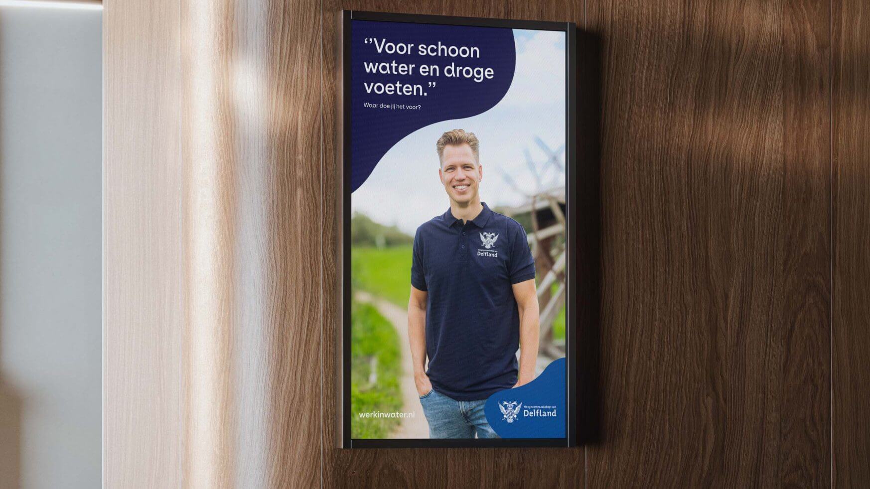 Lachende man in marinehemd op buitenposter met Nederlandse tekst over schoon water en droge voeten.