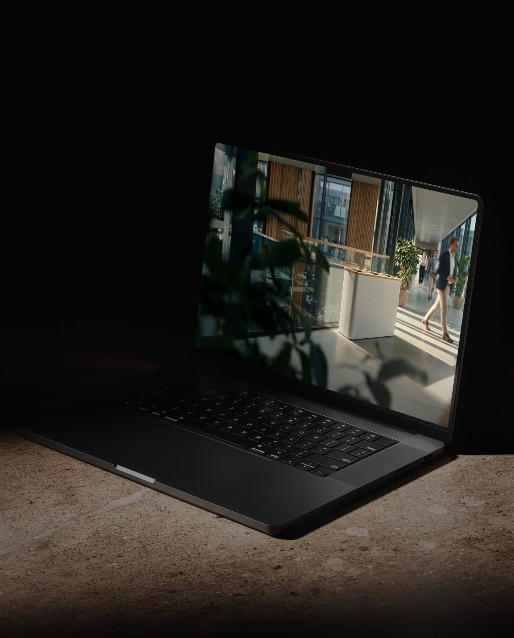 Laptop op stenen oppervlak met een moderne kantoorscène die het dagelijkse werkleven weerspiegelt.