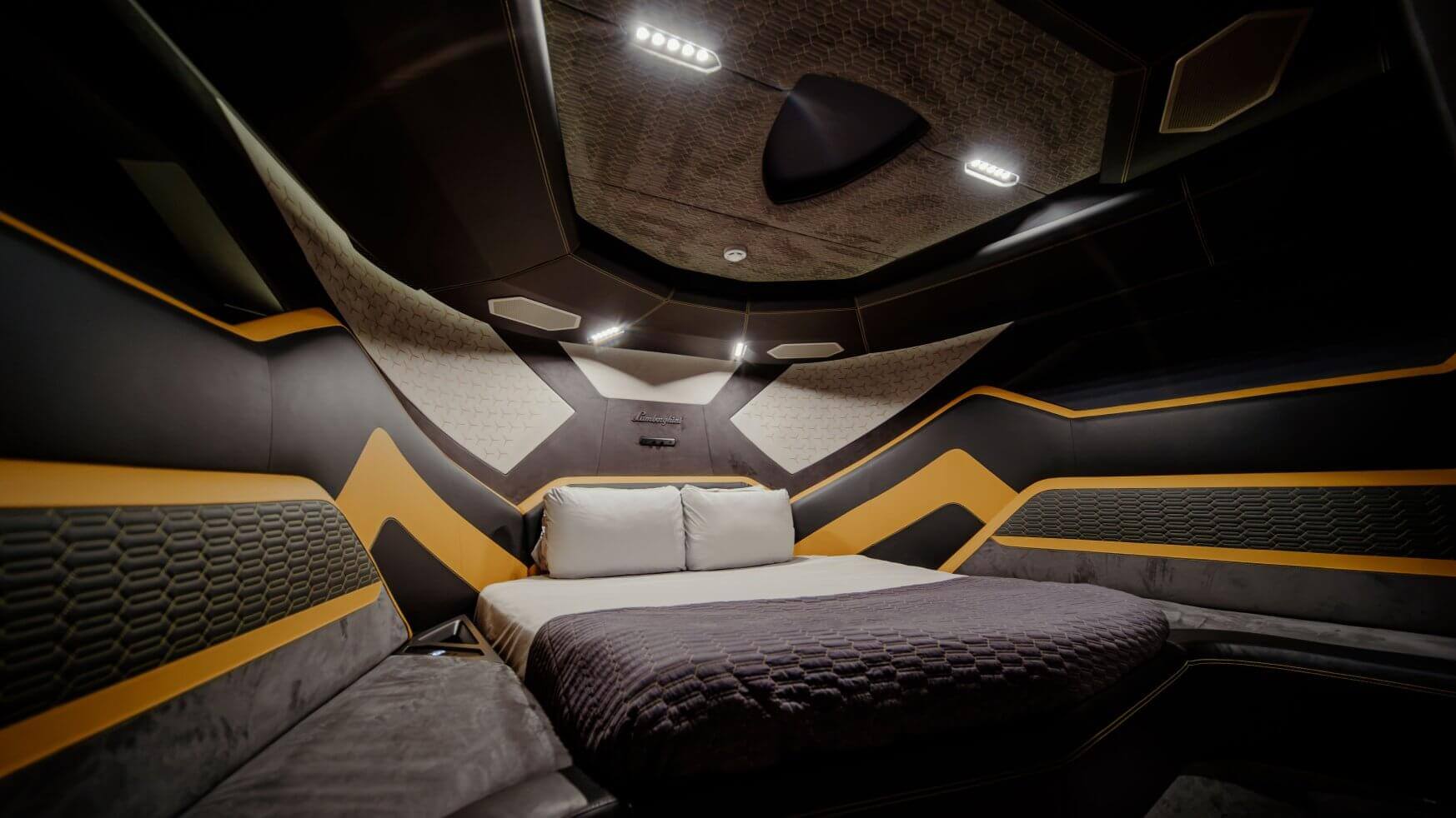 Moderne slaapkamer met zwarte en gele geometrische accenten en een Lamborghini-embleem.