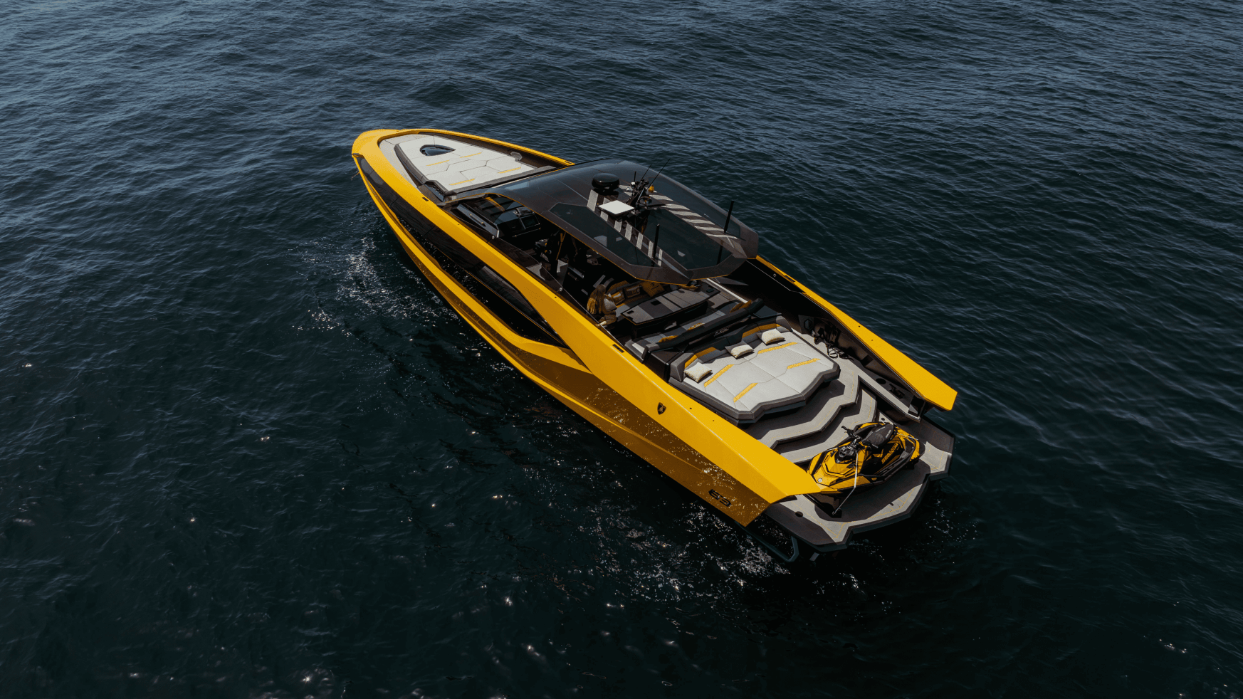 Luchtfoto van een gele speedboot die door het donkerblauwe water snijdt.
