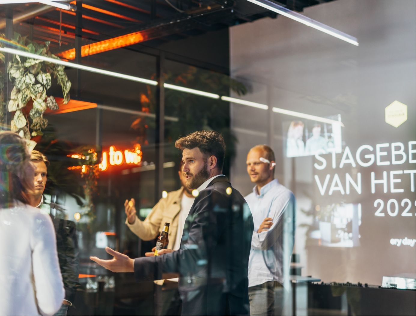 Moderne chat bij een raam, met Stageberg Van Het 2023 op de achtergrond.
