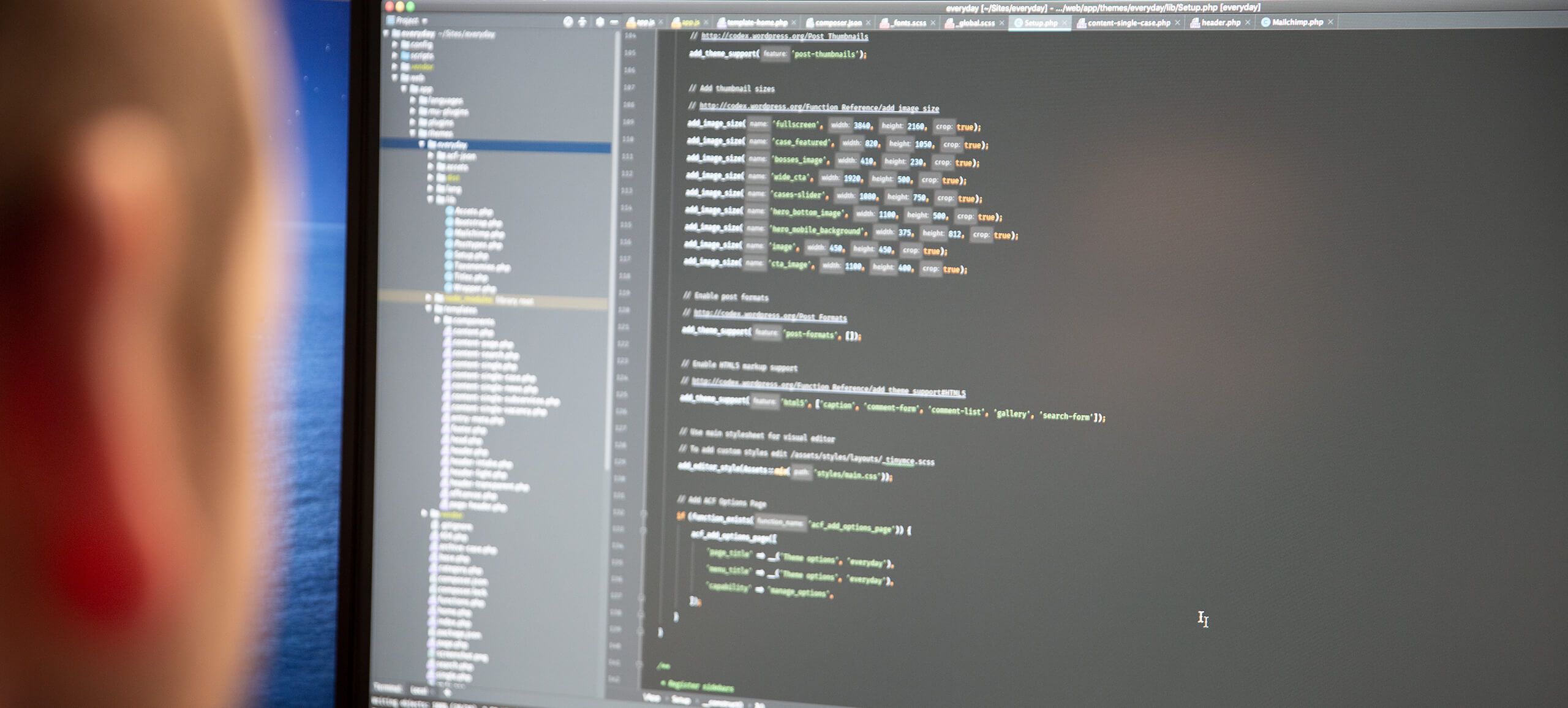 Een professional bekijkt de code op het scherm; een bestandsdirectory ondersteunt het cruciale B2B-ontwikkelingsproces.