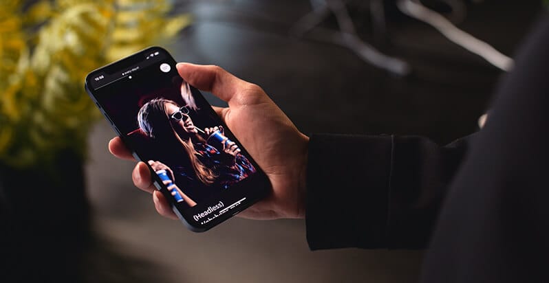 Iemand bekijkt op zijn smartphone een websiteontwerp voor Roosendaal; een plant op de achtergrond zorgt voor rust.