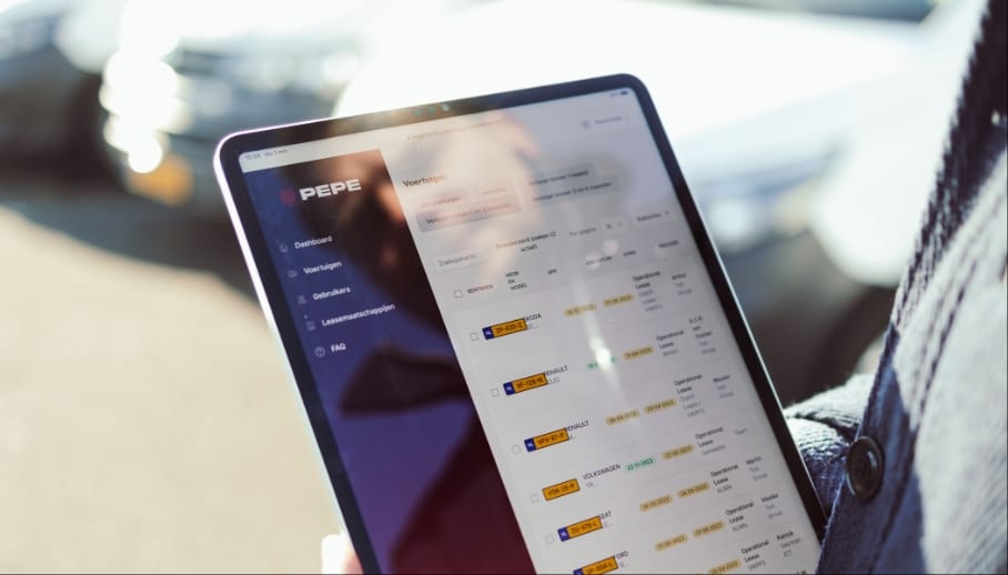 Iemand gebruikt een tablet met een dashboard van een auto bij geparkeerde auto's, een voorbeeld van innovatie in de stijl van Koppert Cress.