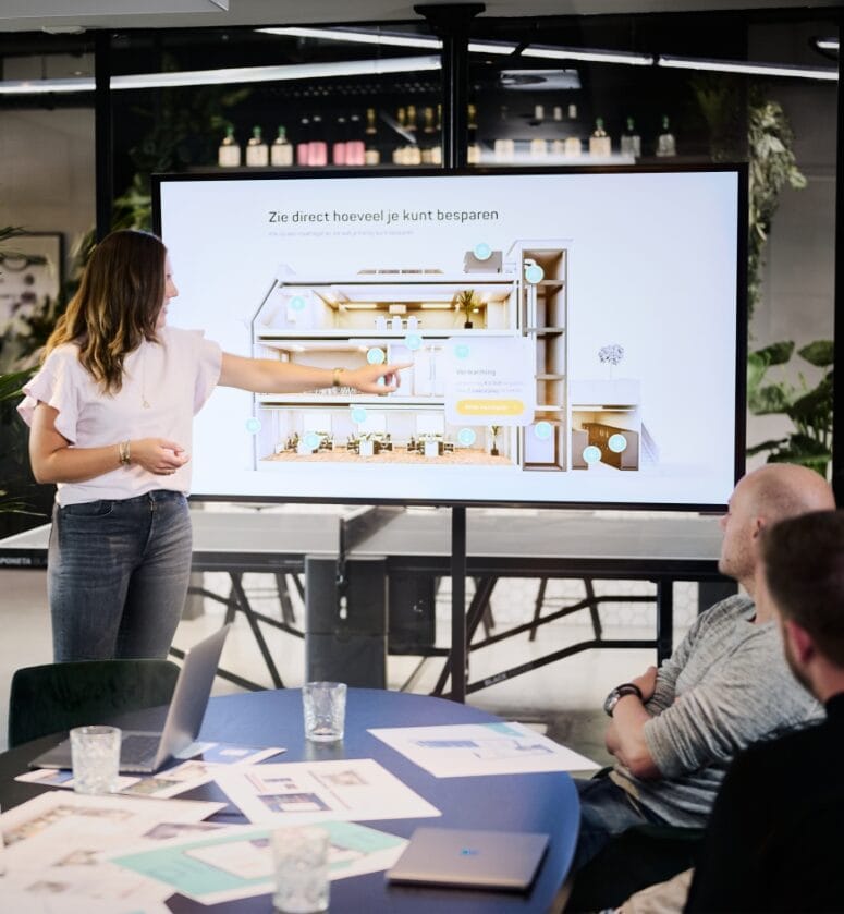 Vrouw presenteert een plattegrond aan drie collega's tijdens een strategische sessie over de structuur en contentplanning van een e-commerceplatform in een modern kantoor.