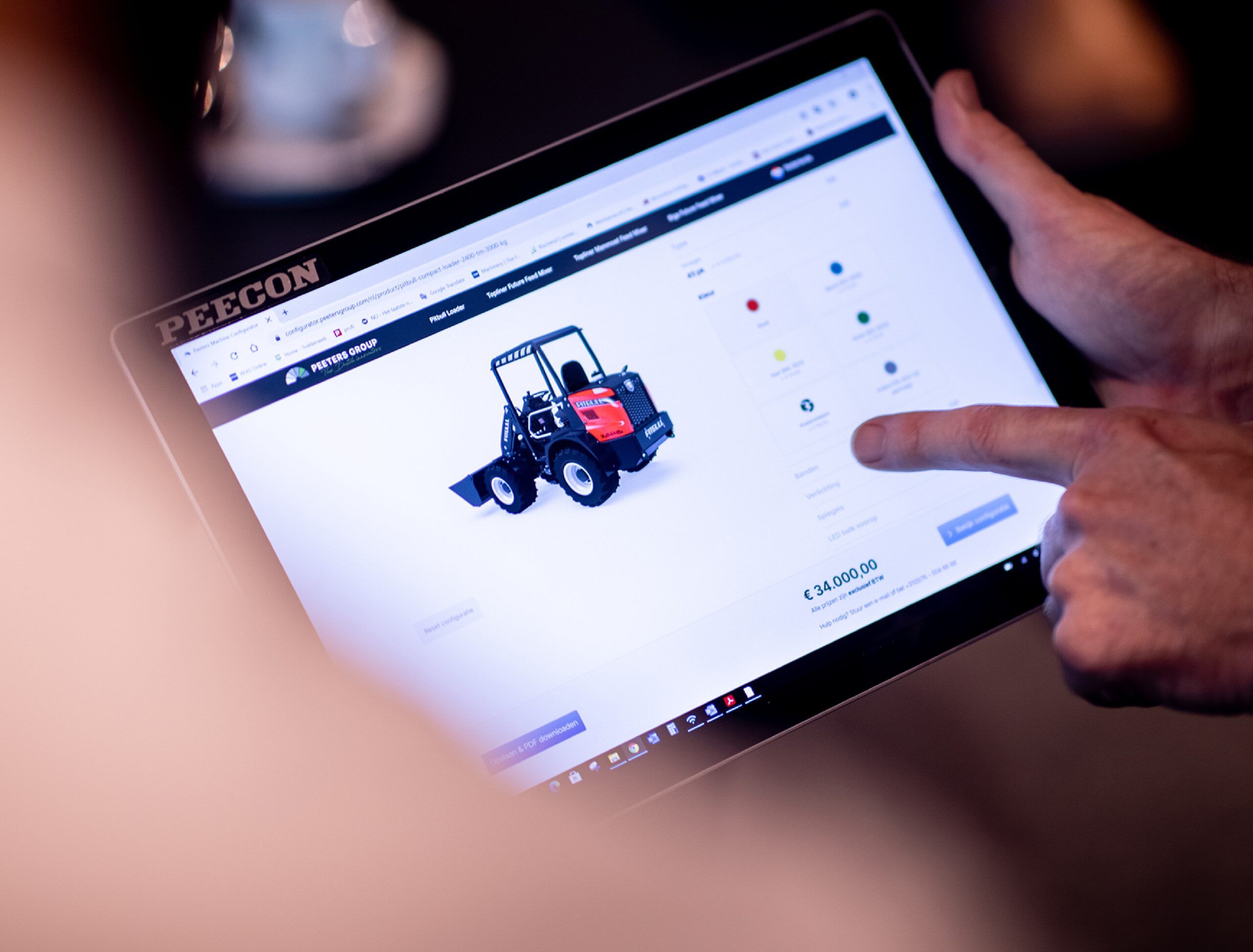 Iemand surft op een winkelsite en bekijkt op zijn tablet een rode tractor.