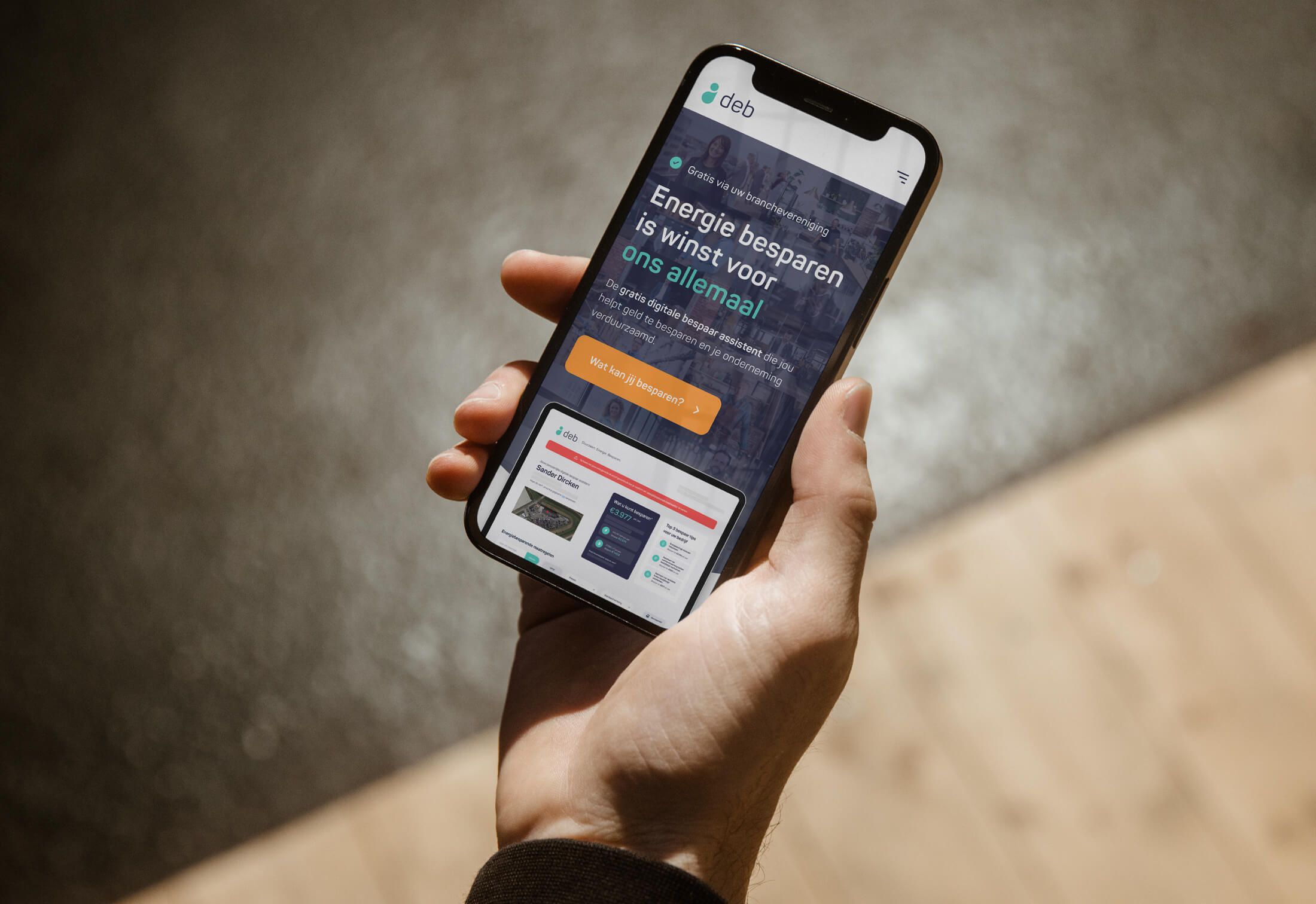 Een persoon houdt een smartphone vast met daarop een website over energiebesparing.