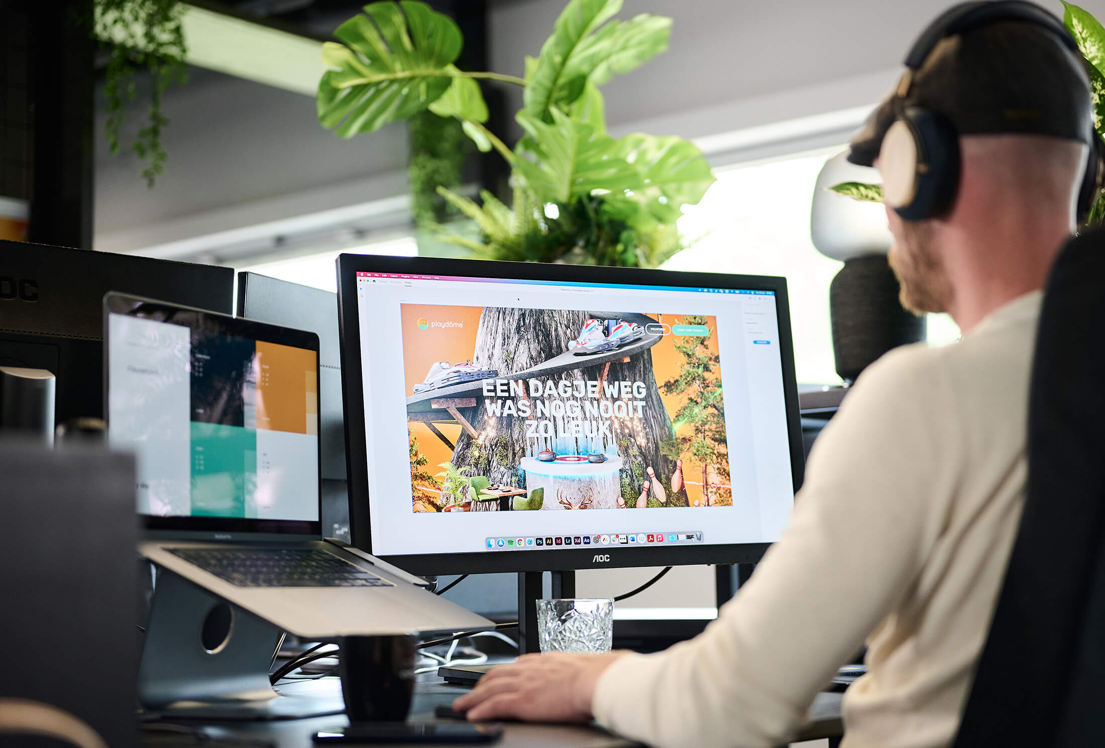 Met een koptelefoon op duiken ze in de levendige wereld van Playdome op een bureaublad, omringd door weelderige planten.