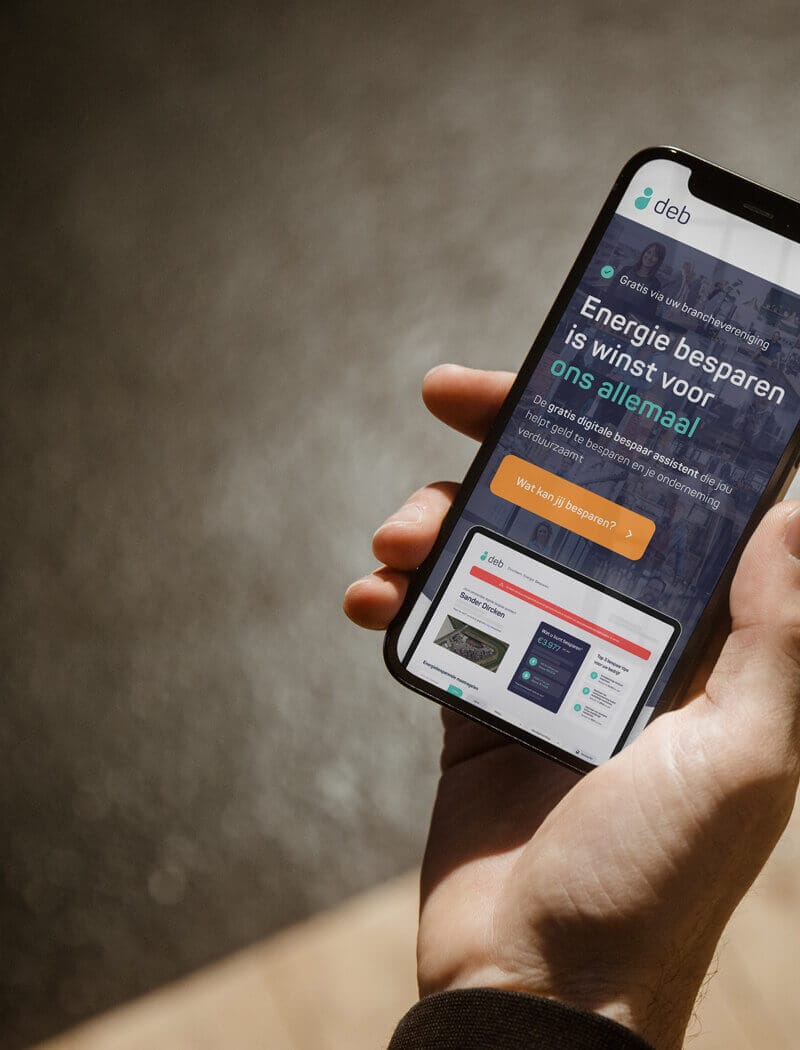 Persoon met smartphone en een Nederlandse energiebesparende site tegen een onscherpe achtergrond.
