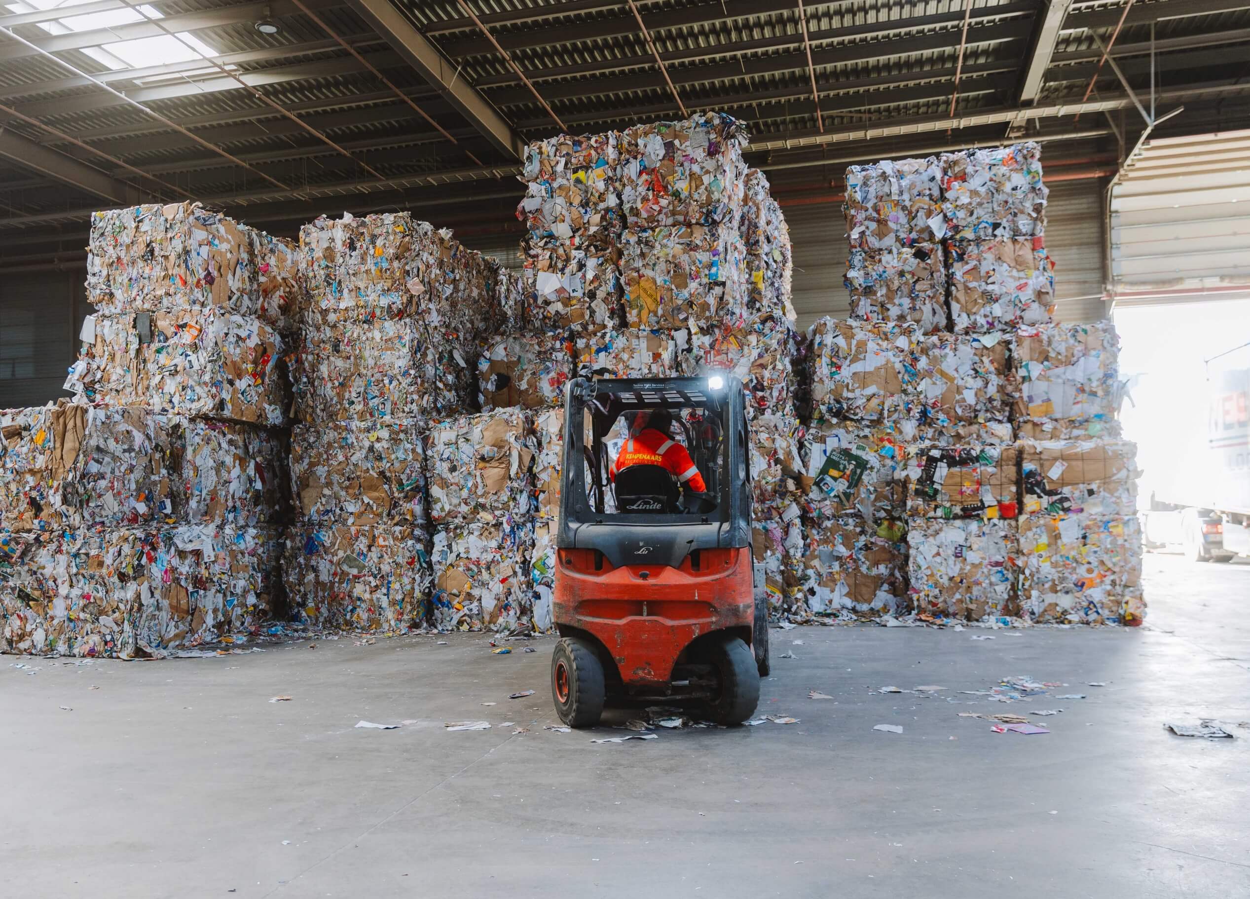 Vorkheftruck vervoert gecomprimeerde recyclebare materialen in het magazijn.