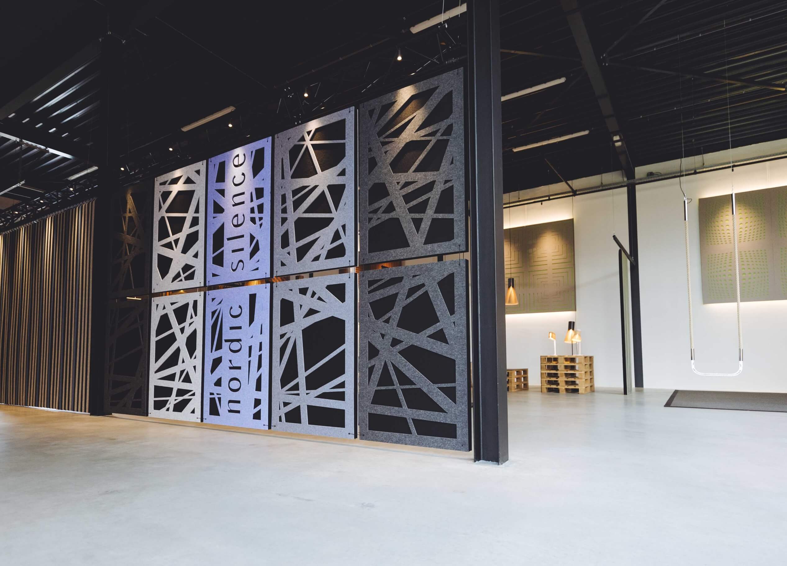 Ontdek een TunnelmaDesign-ruimte: geometrische muren, hoge plafonds en minimalistische inrichting creëren een open, moderne sfeer.