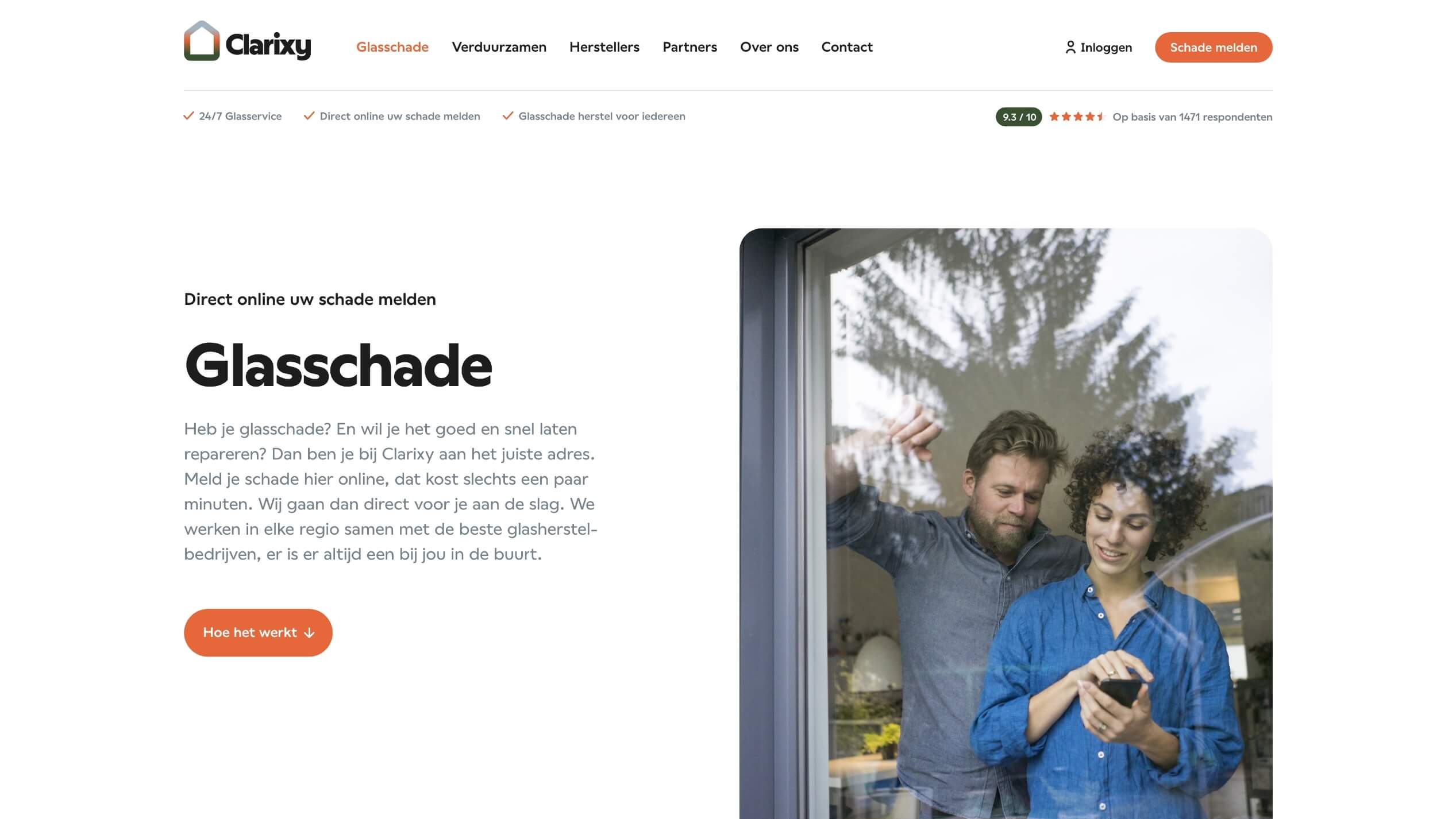 Een stel zit bij een gebarsten raam, gefocust op hun telefoon.