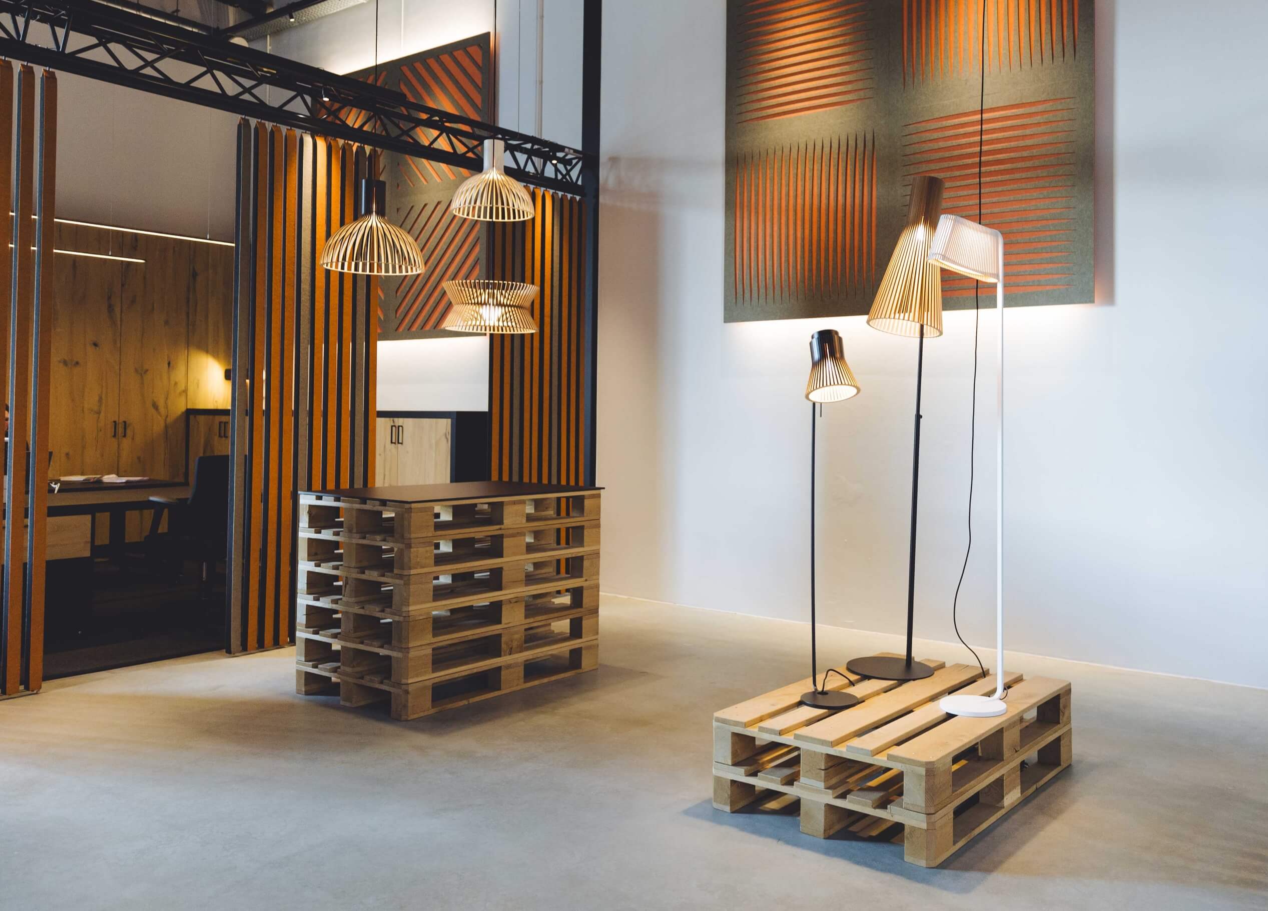 Ontdek de showroom van TunnelmaDesign met palletmeubilair, stijlvolle verlichting en akoestische panelen voor perfecte harmonie.