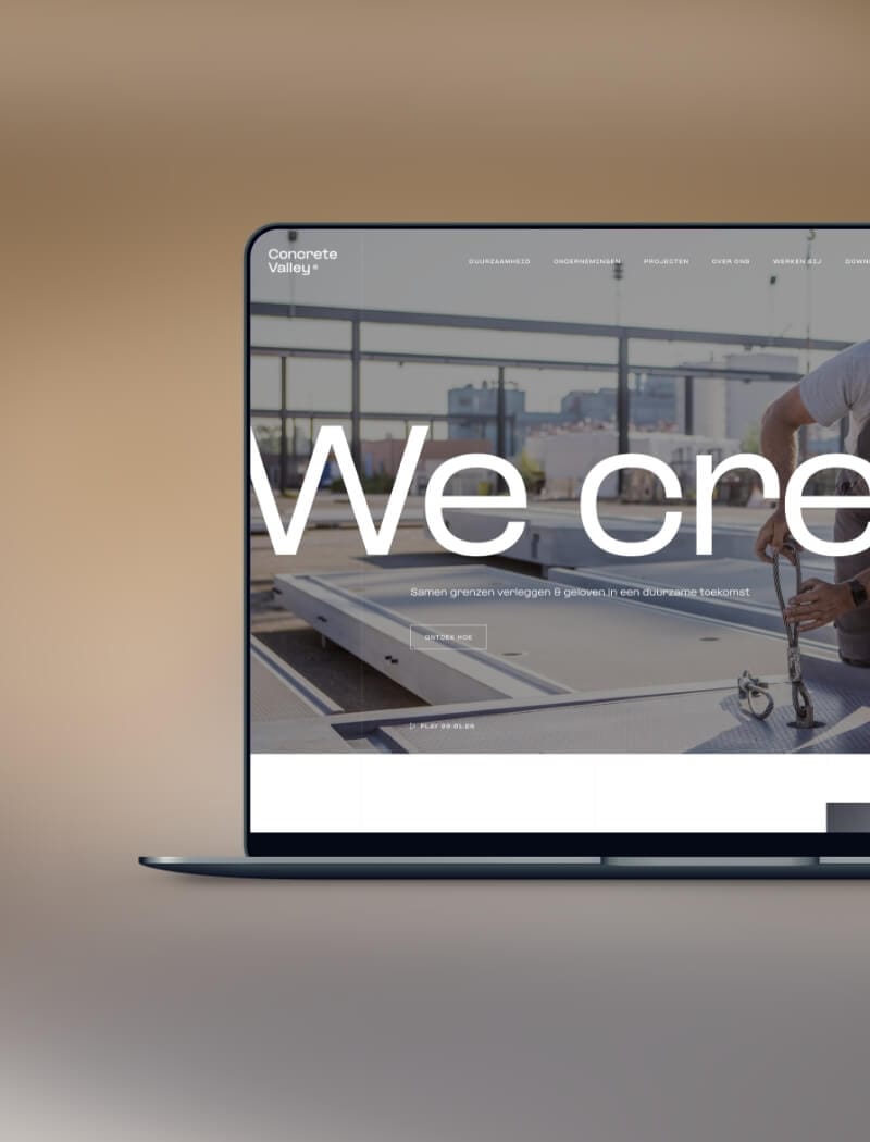 Laptop met een afbeelding van een locatie met "We cre..." tegen een industriële achtergrond.