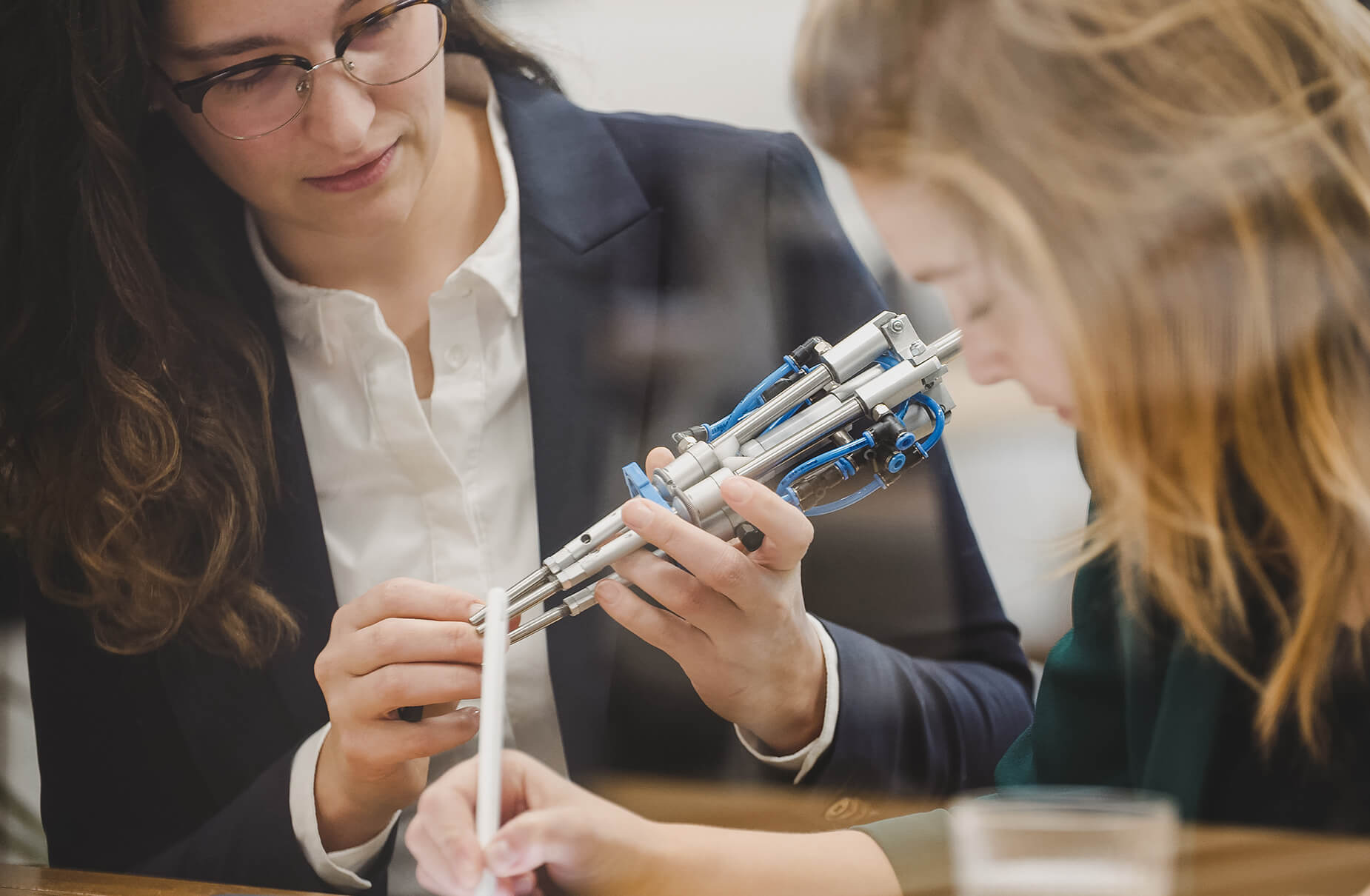 Twee vrouwen bij Viscon Group: de een inspecteert een apparaat, de ander noteert observaties.