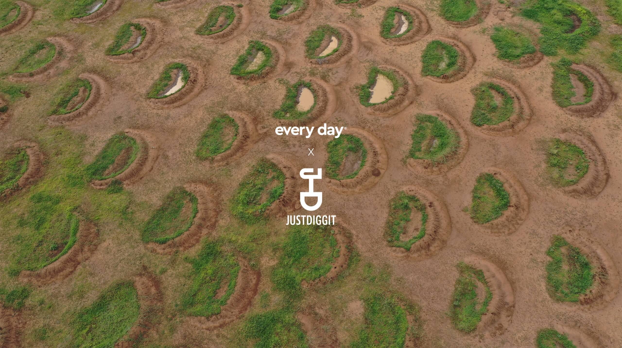 Luchtfoto: Droog terrein bezaaid met groene halve manen en plassen. Tekst: "Every Day" met een scheppictogram.
