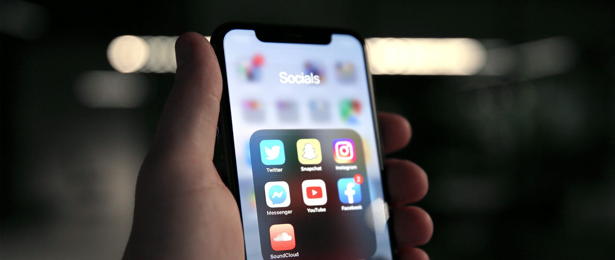 Hand vasthouden van een smartphone met social media-apps, ideaal voor het onder de knie krijgen van SEO- en SEA-strategieën.