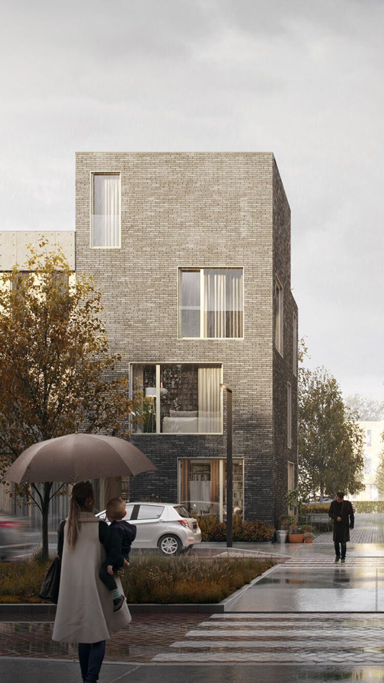 Een vrouw met een CS Wonen-paraplu draagt een kind langs een modern grijs bakstenen gebouw in de regen.