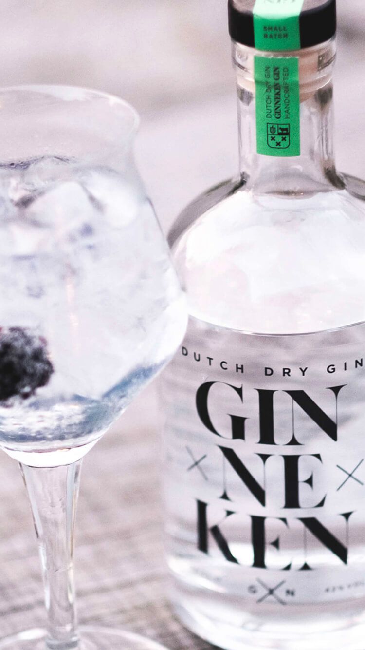 Nederlandse droge gin van GinnekenGin.com met een met bessen versierd ijsglas.