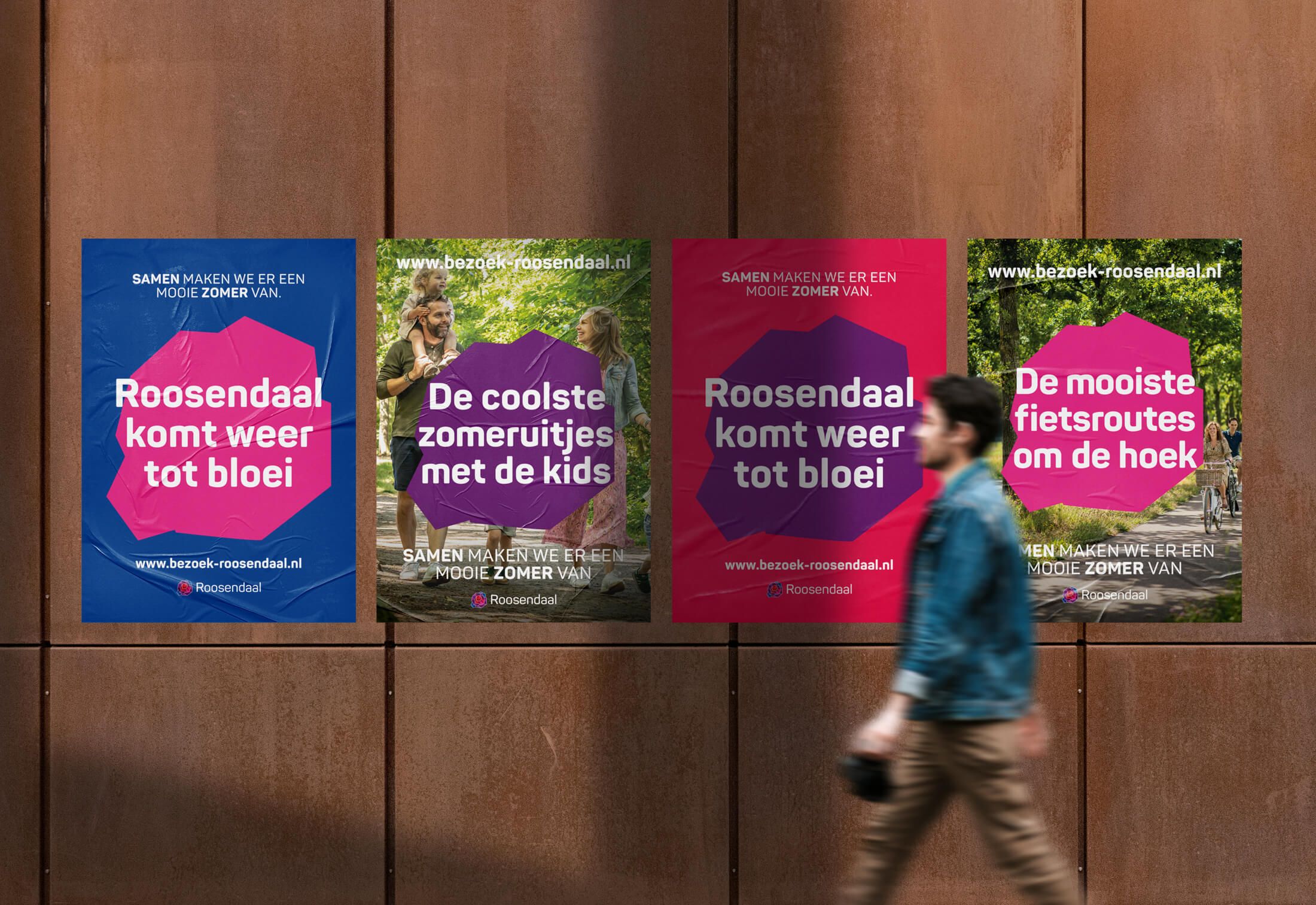 Een persoon loopt langs een muur die versierd is met vier opvallende posters van evenementen in Roosendaal.