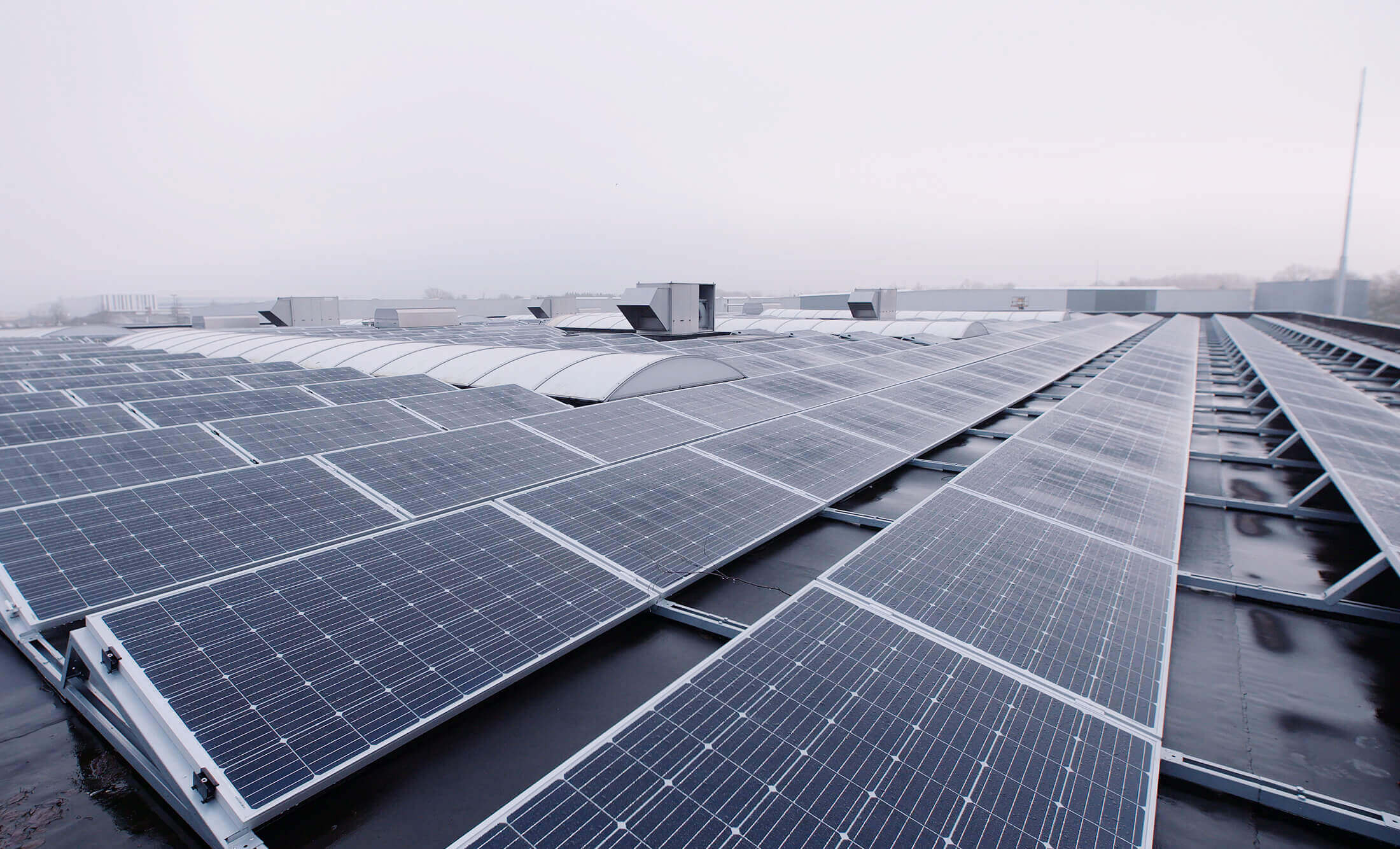 YMX Euro Solar-zonnepanelen zijn vakkundig aangebracht op een industrieel dak en benutten efficiënt energie, zelfs op bewolkte dagen.