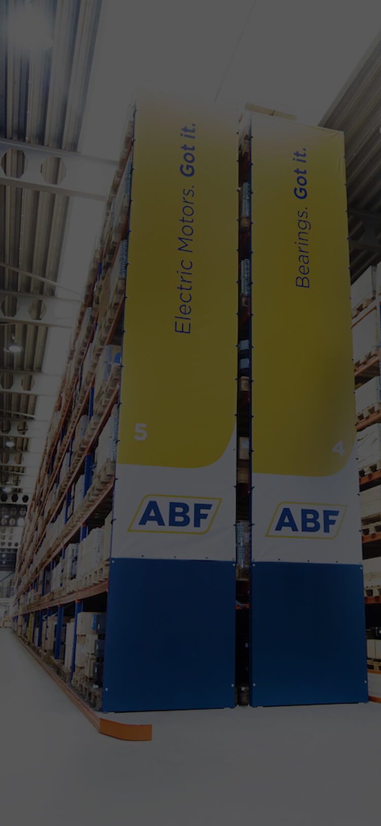 Hoge schappen met ABF-logobanners tonen trots elektromotoren en lagers in het gangpad van het magazijn.