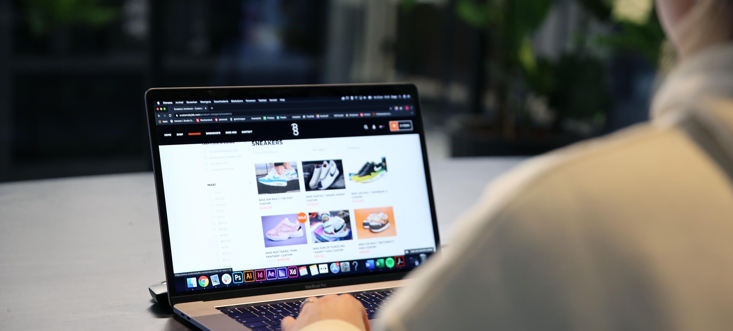 Een gebruiker bladert op zijn laptop door een schoenensite en ziet trendy sneakercampagnes die gericht zijn op liefhebbers.