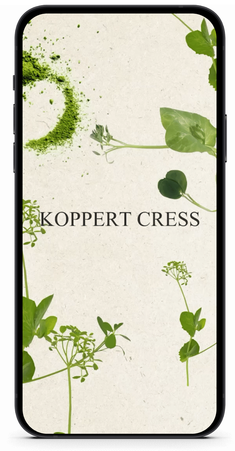 Een telefoon toont de apps So Syncd en KOPPERT CRESS, tussen groene bladeren op een beige achtergrond.
