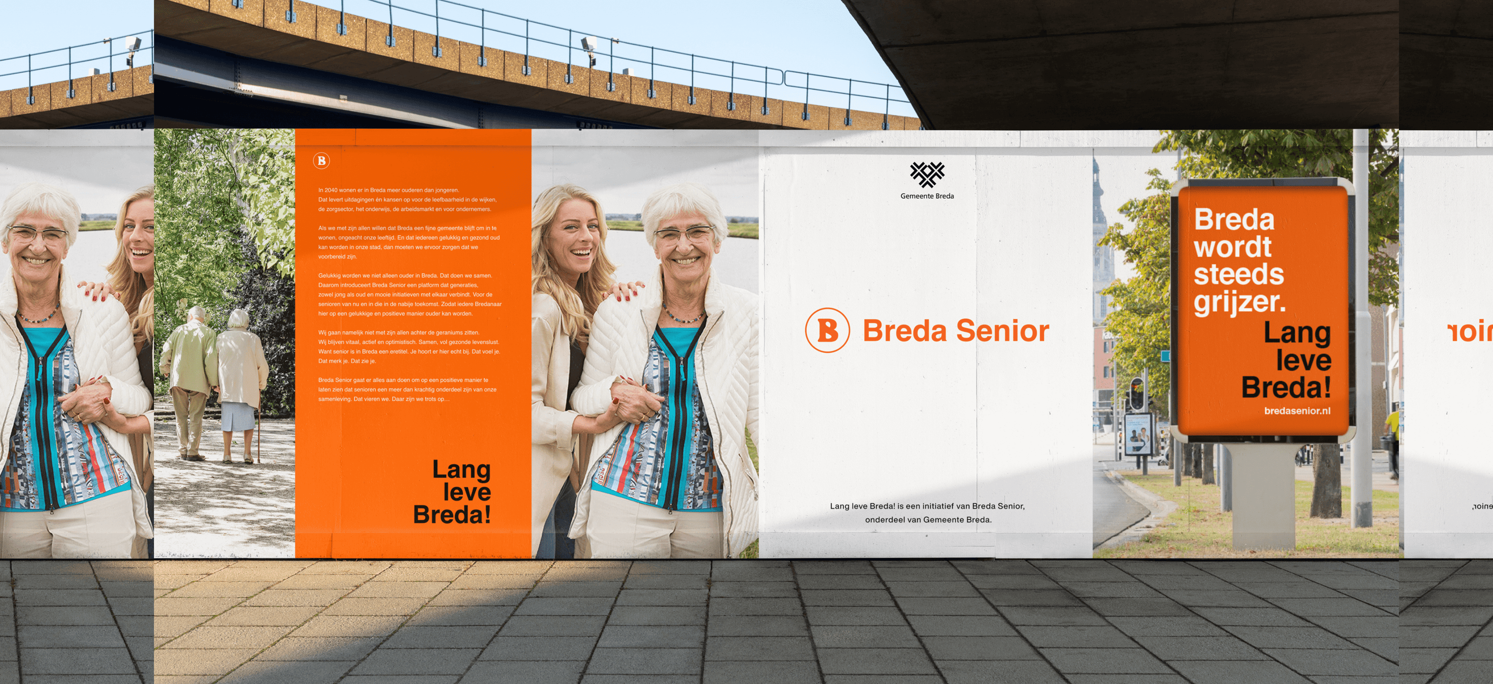 Een oudere volwassene en een jongere vrouw lachen naast een poster van Breda Senior onder een brug in Roosendaal.